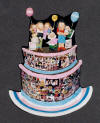 Personalized clay figurine, an  anniversary gift for 10th year...photographer dad with dr.mom and their 3 kids perched on top of cake decorated with photo montage of their married lives.