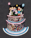 Personalized clay figurine, an anniversary gift for 10th year...photographer dad with dr.mom and their 3 kids perched on top of cake decorated with photo montage of their married lives.